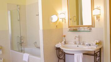Un baño con bañera, lavamanos, espejo y ducha.
