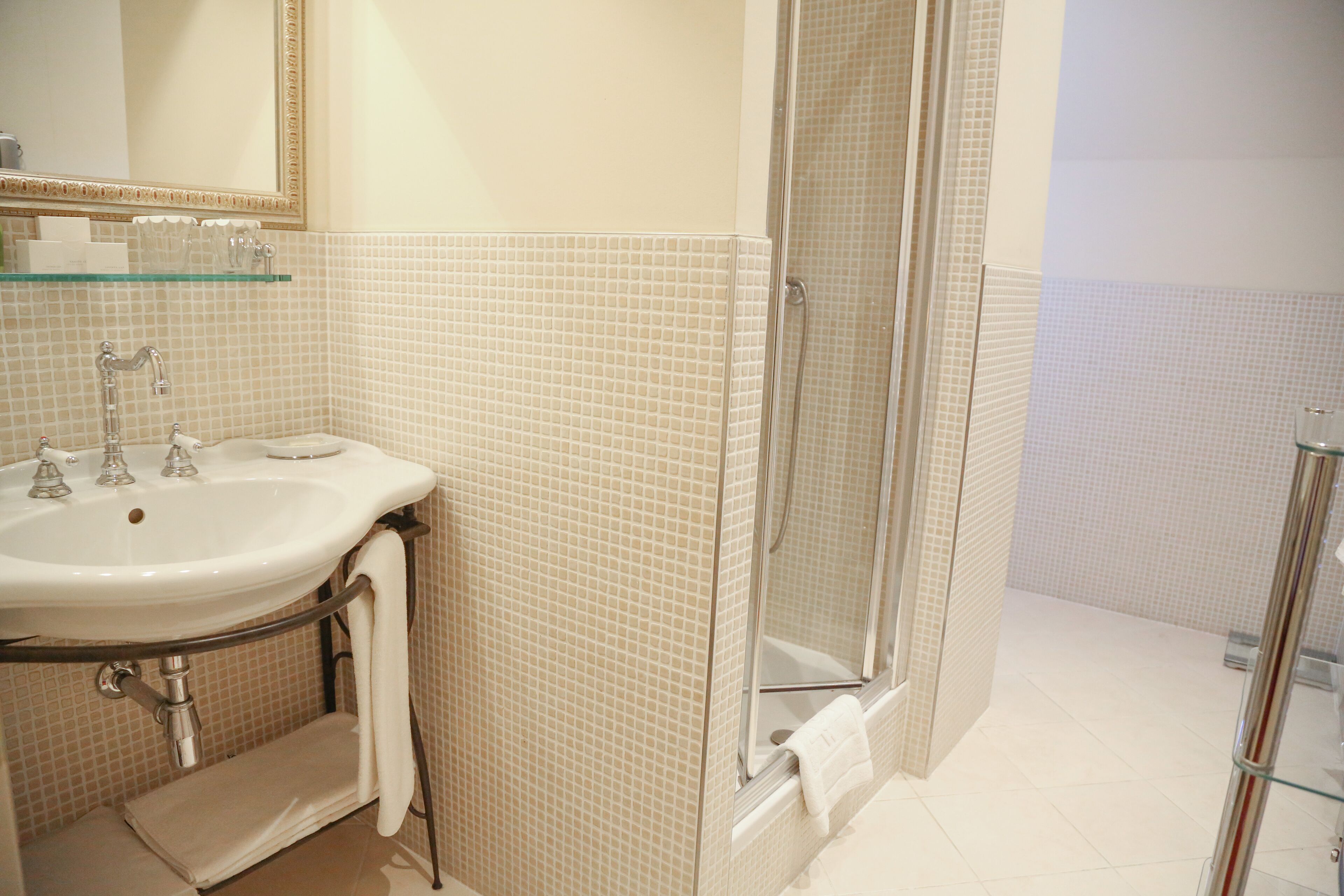 Une salle de bain avec un lavabo, un miroir et une douche en verre.