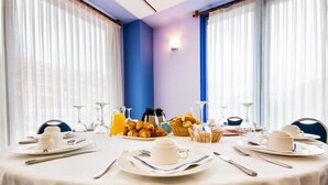 A breakfast table set with plates, cups, cutlery, and a basket of croissants. - Viadero (Noja)