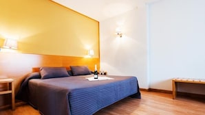 A neatly arranged hotel room with a bed, bedside tables, and a nightstand. - Viadero (Noja)