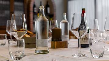 Une table dressée avec des verres à vin, des bouteilles et une fourchette, ce qui indique qu’un repas ou une dégustation va avoir lieu.