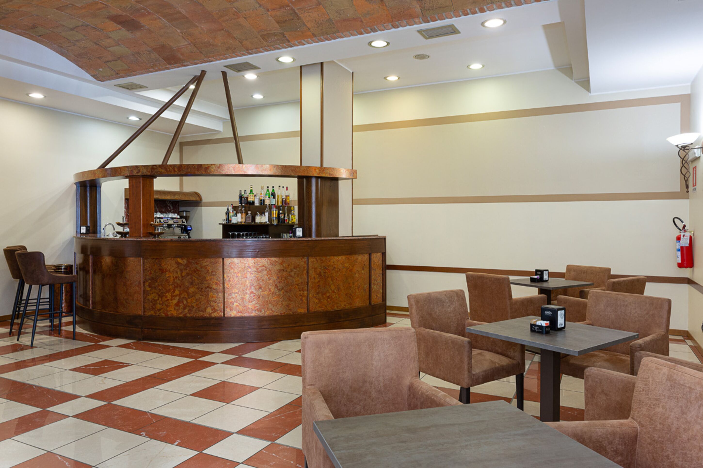 A lobby with a bar area, seating, and a fire extinguisher on the wall.