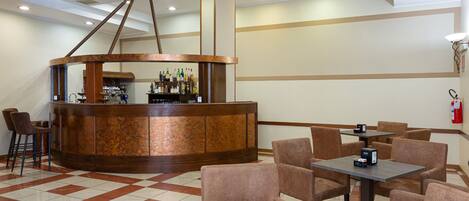A lobby with a bar area, seating, and a fire extinguisher on the wall.
