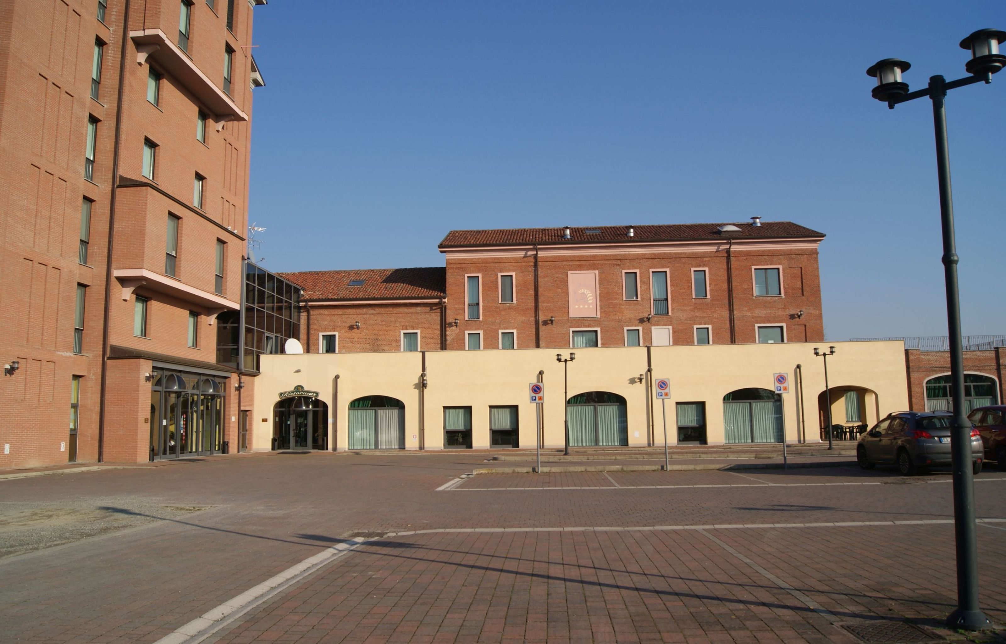 Un edificio a più piani con facciata in mattoni, ampie finestre e tetto piano.