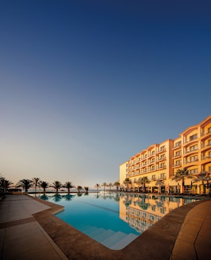 A hotel with a swimming pool, palm trees, and a clear sky. - Vila Gale Santa Cruz Resort Hotel (Santa Cruz)