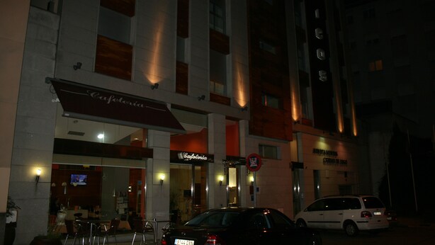 A building with a cafe named "Cafe del Sol" and a sign for "Hotel de la Mer." There are outdoor seating areas and a parked car in front. - Hotel Ciudad De Lugo (Lugo)