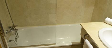 A bathroom with a bathtub, a shower, and a sink.