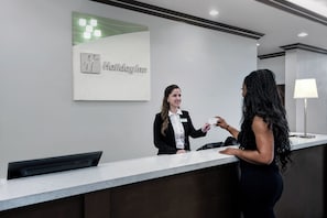 A hotel reception desk with a sign indicating it's a Holiday Inn.
