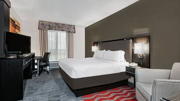 A hotel room with a bed, desk, chair, television, and a telephone.