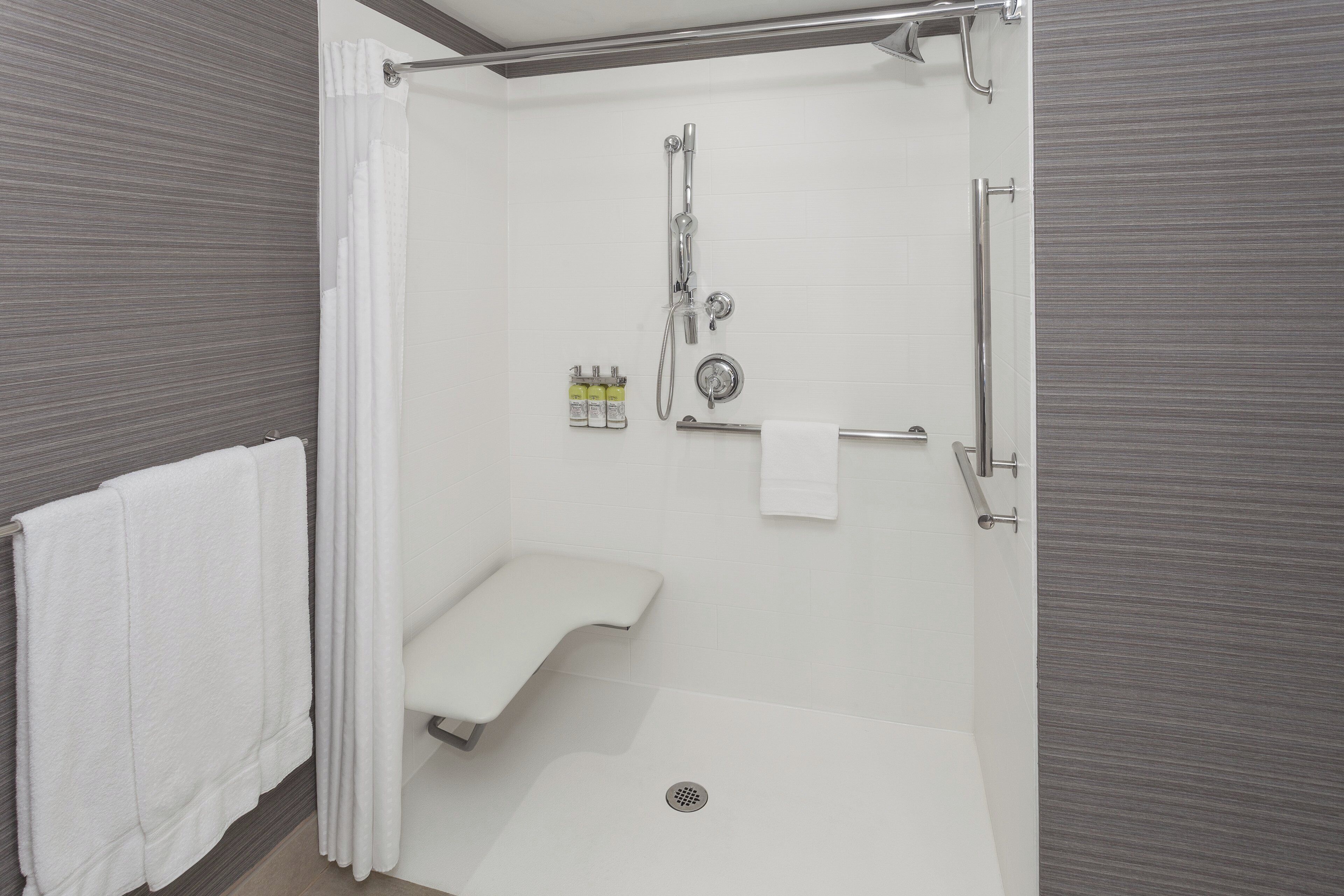 Un baño moderno con cabina de ducha, inodoro y toallero.