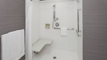 A modern bathroom with a walk-in shower, a toilet, and a towel rack.