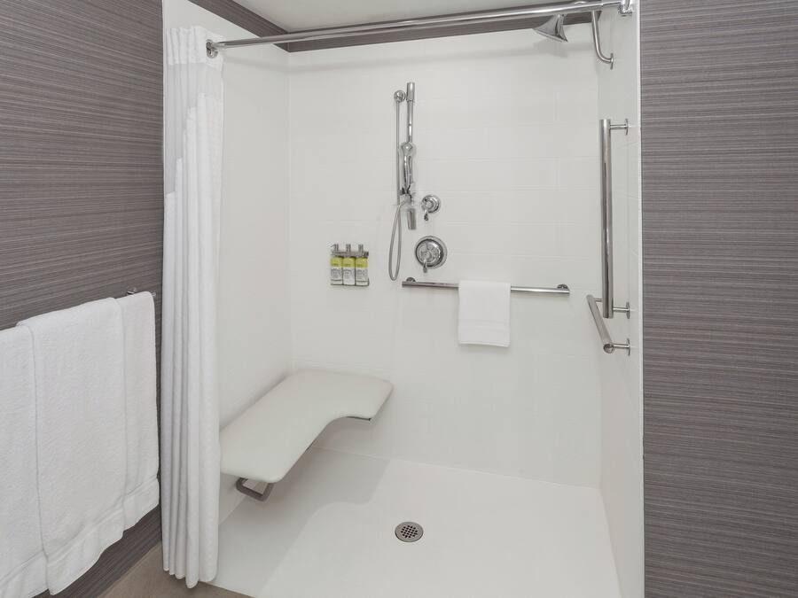 A modern bathroom with a walk-in shower, a toilet, and a towel rack.