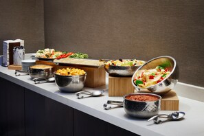 Un'attrezzatura per buffet con diversi cibi e utensili.