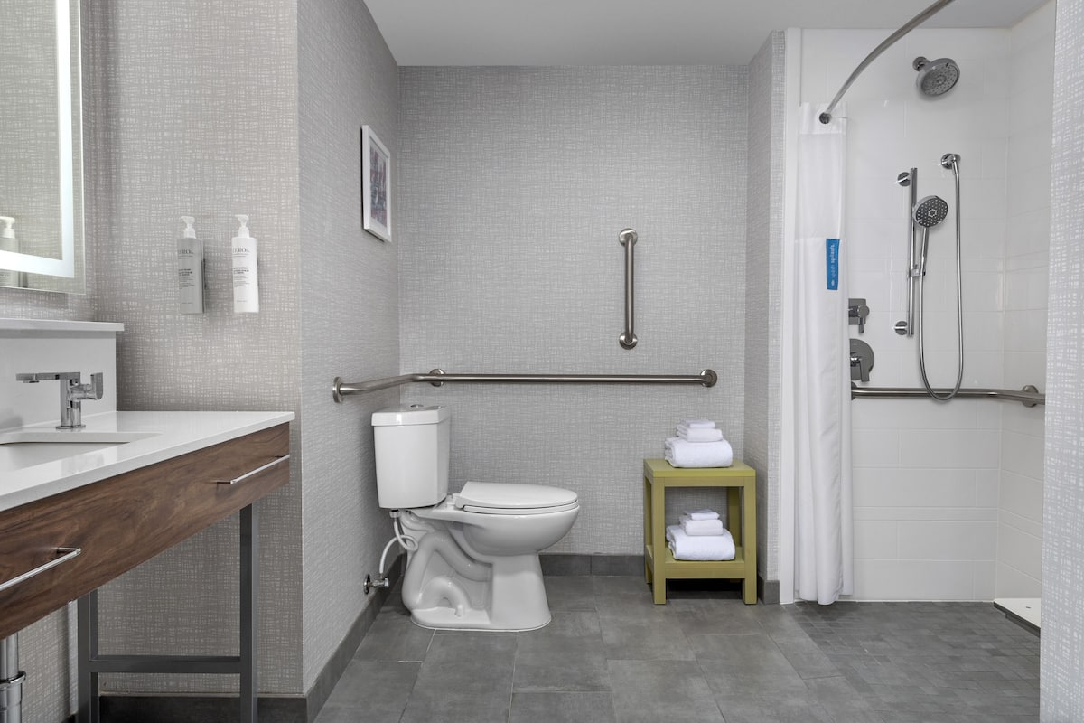 A modern bathroom with a toilet, sink, and shower area.