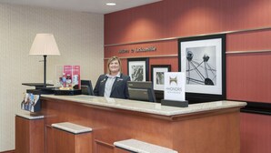Una recepción con una mujer detrás, un cartel enmarcado que dice "Welcome to Jacksonville" y una imagen enmarcada de una noria.