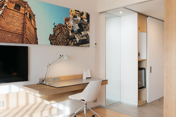 A modern office space with a desk, chair, and a large painting of a cityscape. - Barcelo Valencia Hotel (Valencia)