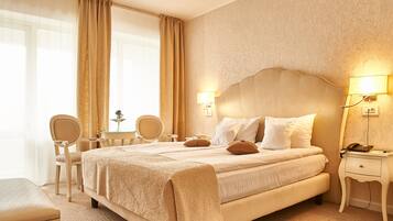 Een hotelkamer met een groot bed, twee nachtkastjes, een bureau en een stoel.