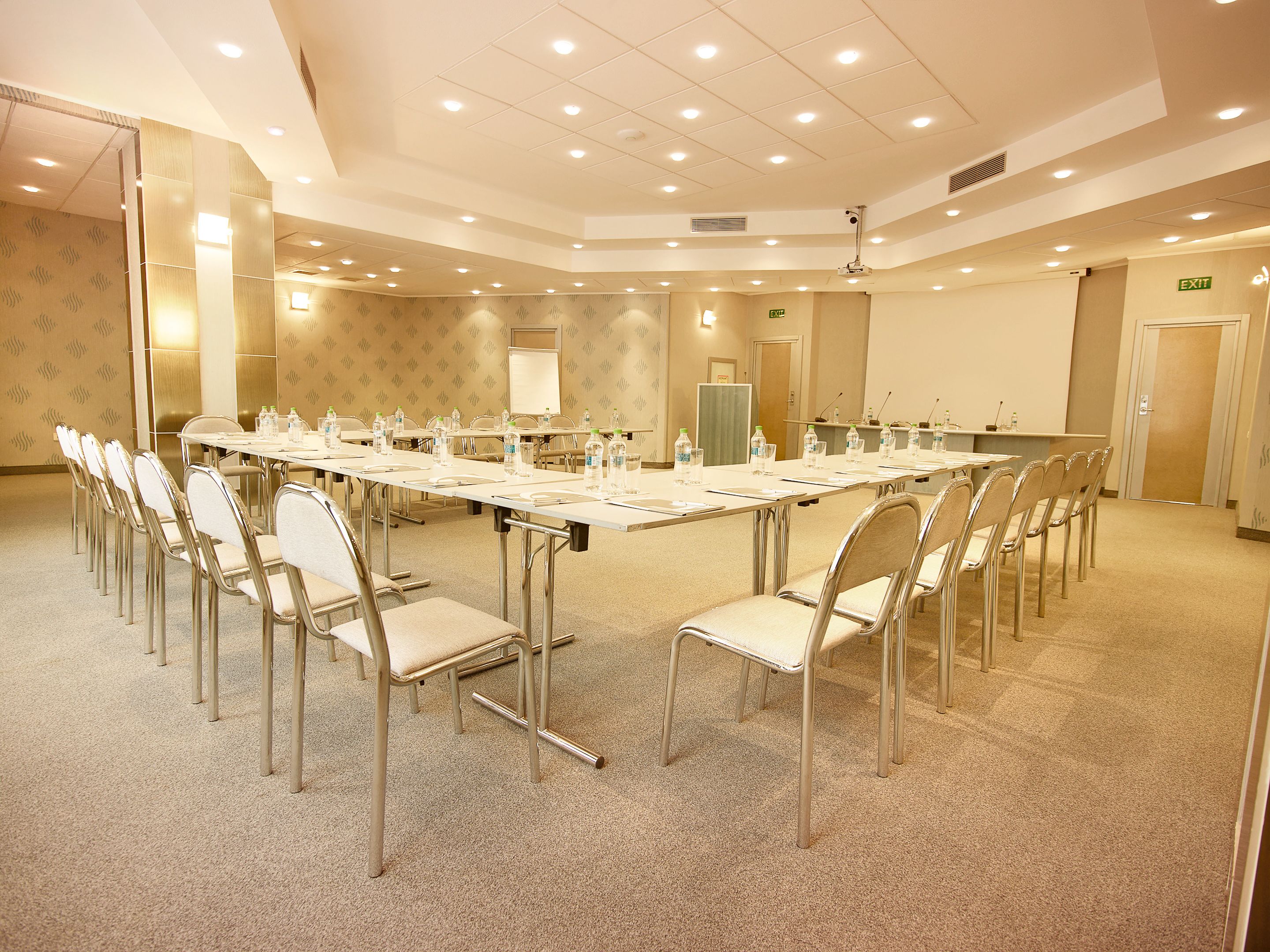 A conference room with a long table, chairs, and a whiteboard.
