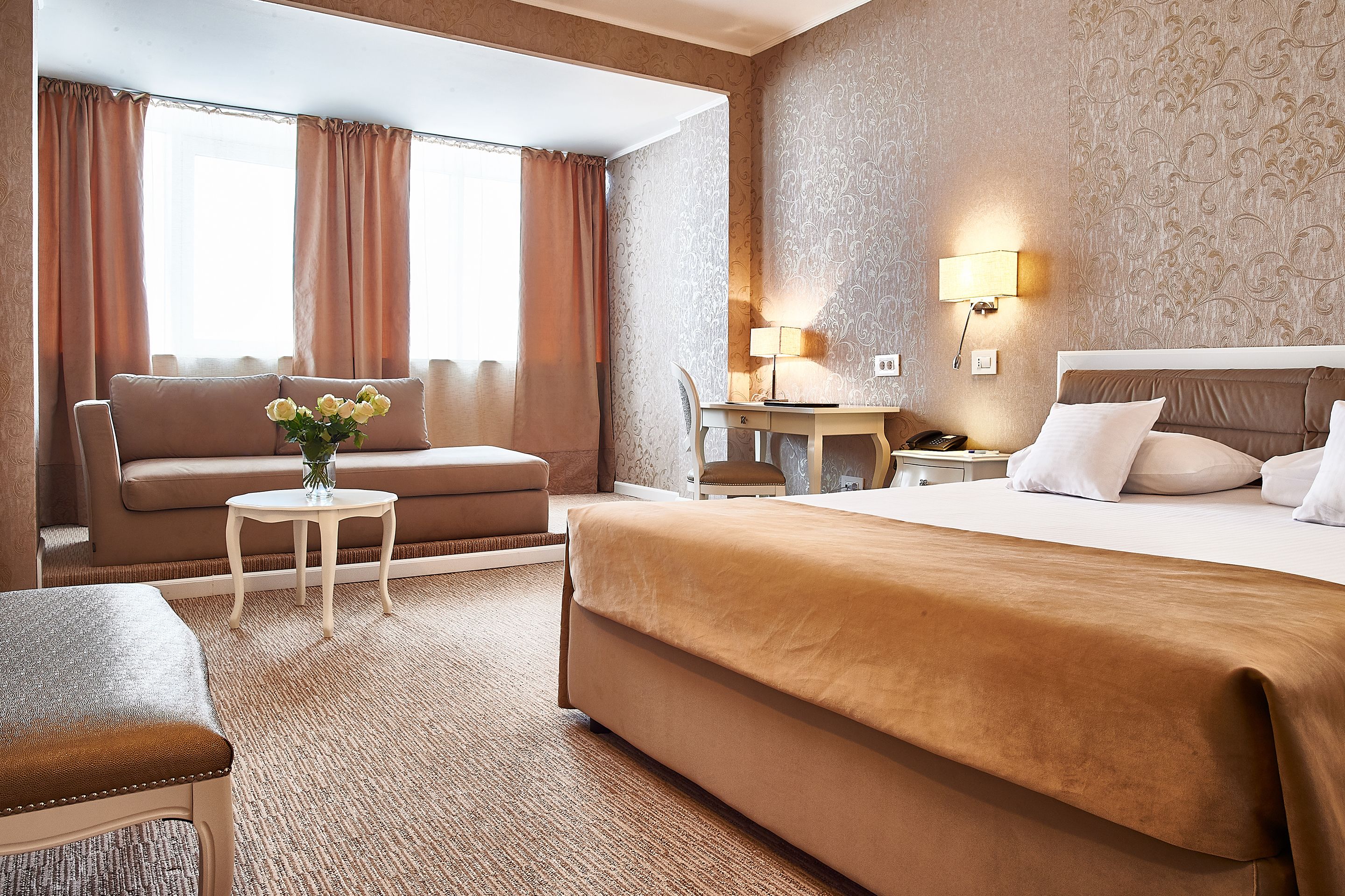 Una habitación de hotel con cama, sofá, escritorio y silla.
