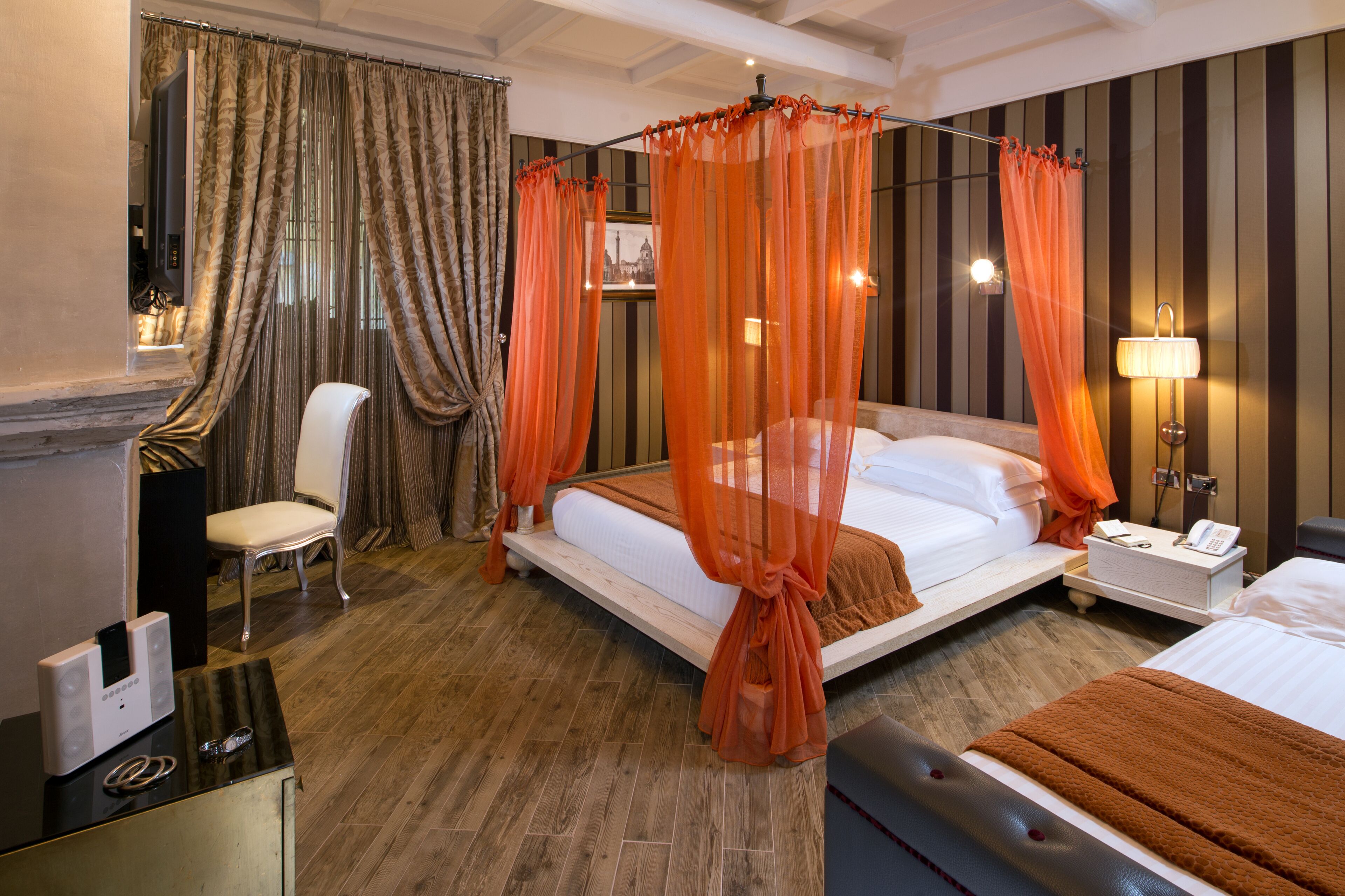 A hotel room with a bed, a chair, a bedside table with a lamp, and a curtain.