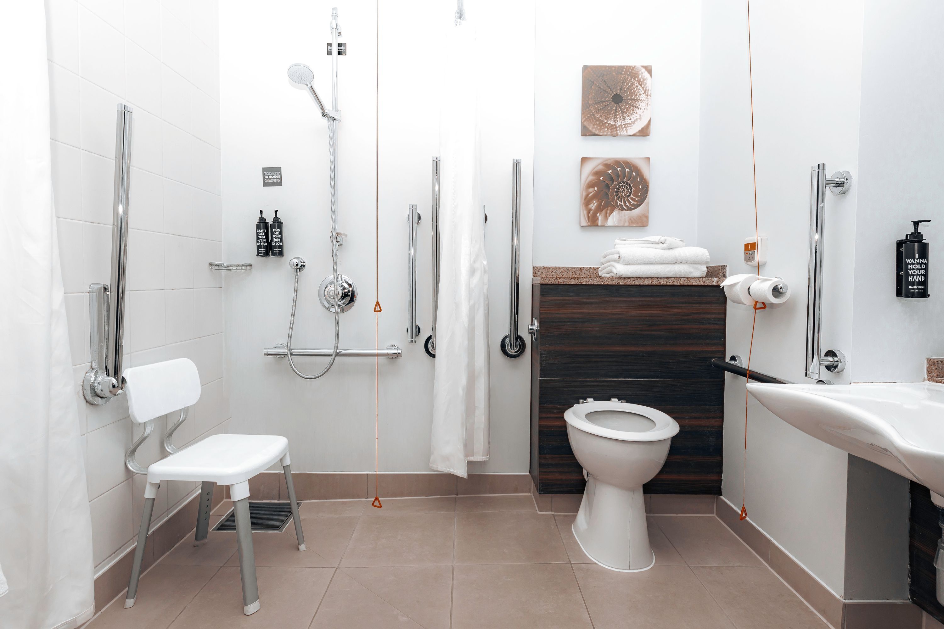 A modern bathroom with a shower, toilet, and sink.