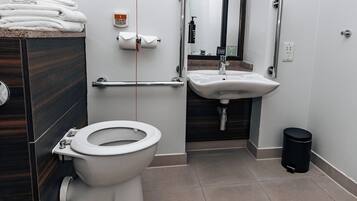 A modern bathroom with a toilet, sink, and hand dryer.