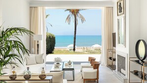Un salon spacieux avec vue sur la plage, comprenant un canapé, une table basse et une cheminée.