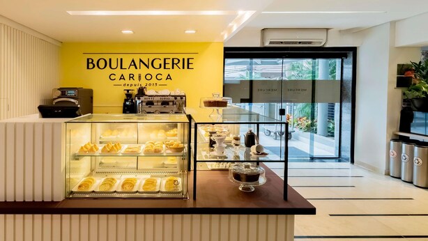 A bakery counter with pastries, a coffee machine, and a sign reading 'BOULANGERIE CARIOCA'. - Mercure Sao Paulo Pamplona Hotel (São Paulo)