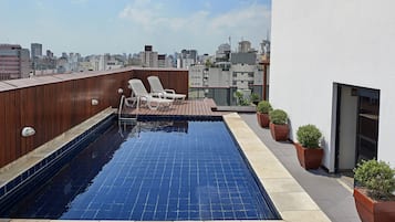 Alberca al aire libre y camastros