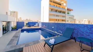 Een buitenzwembad en ligstoelen