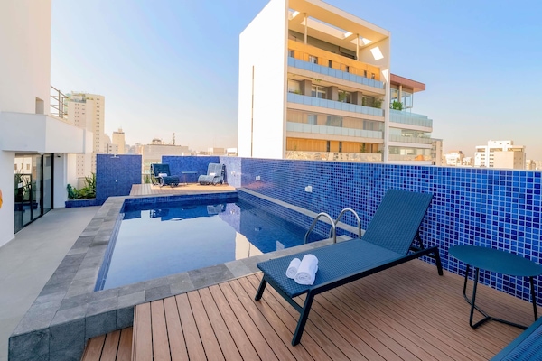 Een buitenzwembad en ligstoelen