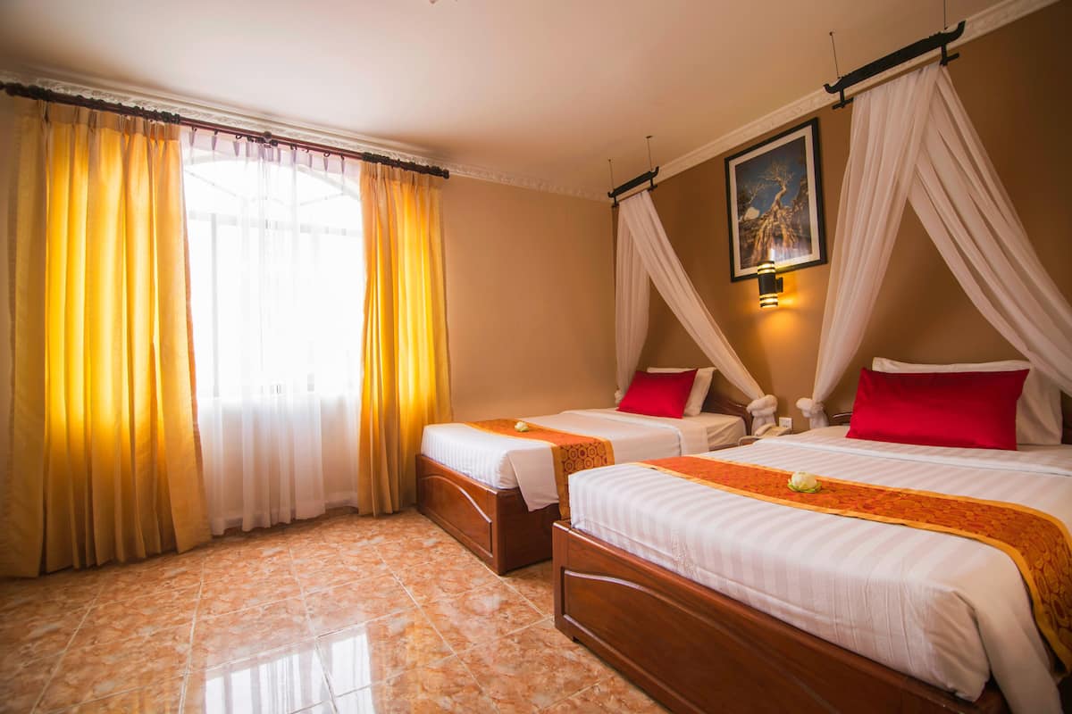 A hotel room with two beds, a large window with curtains, a painting on the wall, and a tiled floor.