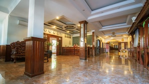 A spacious lobby with marble flooring, wooden columns, and a reception desk. - Reaksmey Chanreas Hotel (Siem Reap)