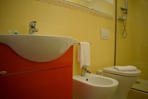 Un baño con lavamanos, bidé e inodoro.