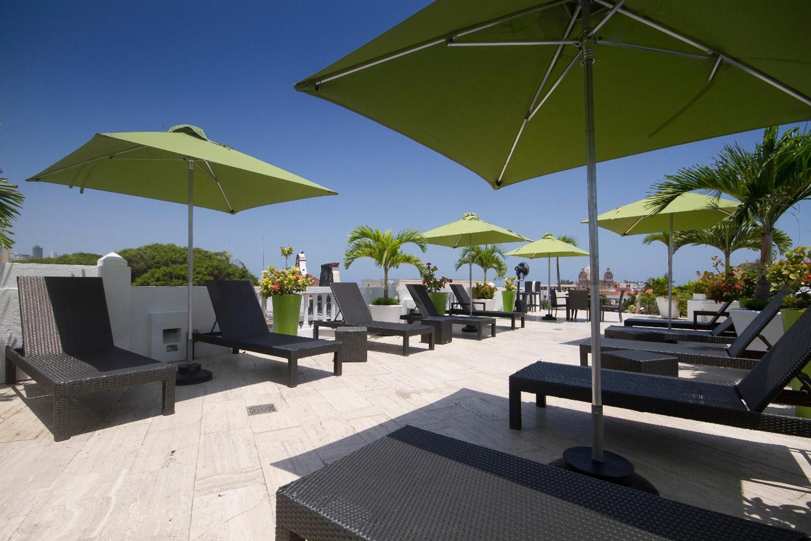 Un espace de détente sur le toit, avec des sièges en plein air et des parasols.