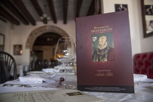 A menu titled "Brasserie Montaigne" with a wine glass and table settings.