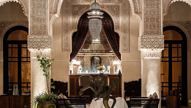 Un hall d’entrée luxueux, agrémenté d’une fontaine centrale, d’arcades décorées et de coins salon.