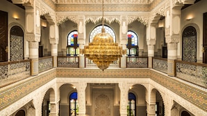 Un intérieur somptueux, orné de motifs complexes en mosaïque, agrémenté d’un lustre central et de fenêtres en arc de cercle.