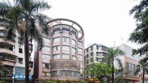A multi-story hotel with a circular central section and a traditional facade. - Zhong Hua Hotel (Guangzhou)