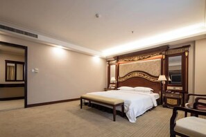 A hotel room with a large bed, a bench, a desk, and a chair. - Zhong Hua Hotel (Guangzhou)