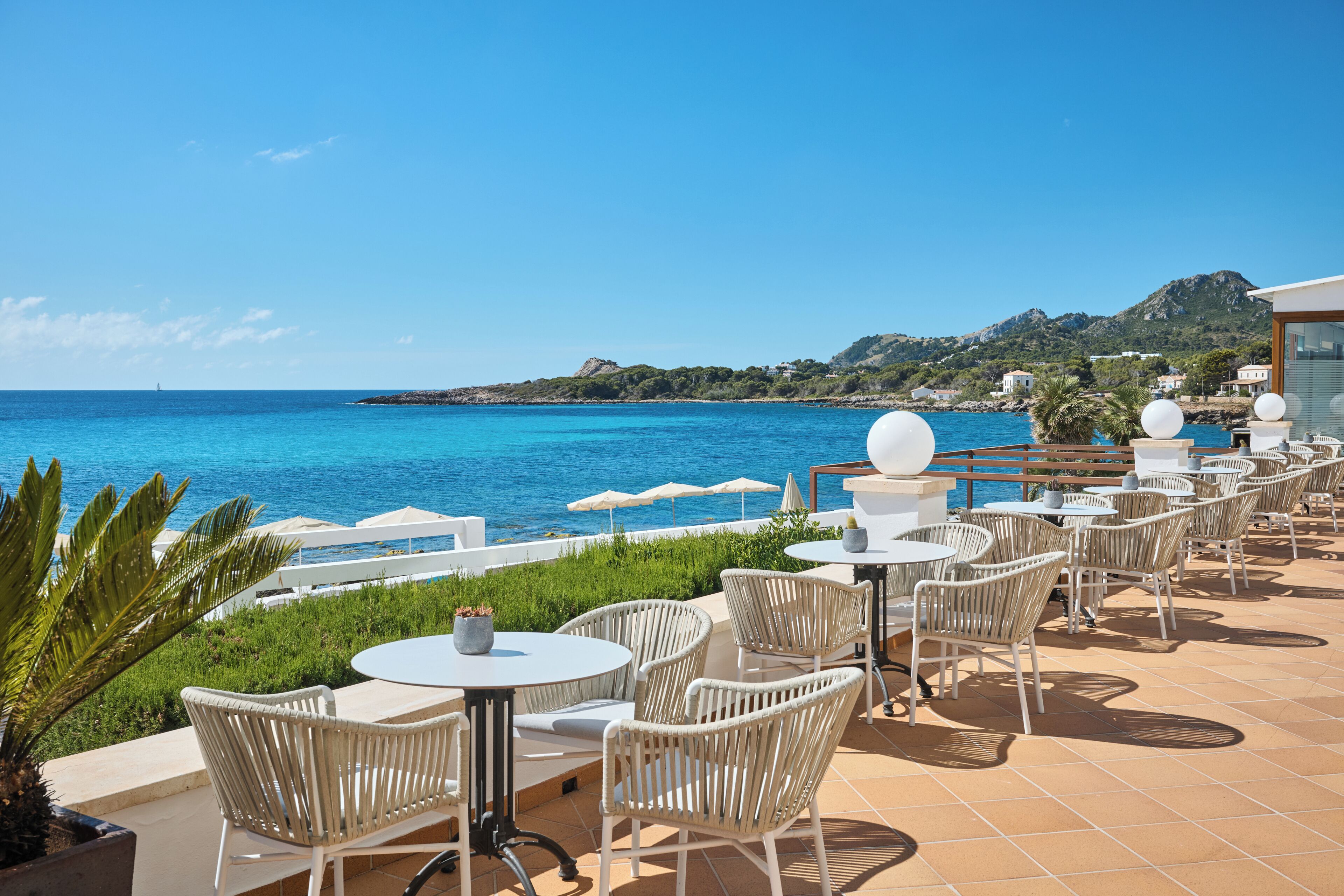 Eine Terrasse am Meer mit Sitzgelegenheiten und Blick auf den Ozean.