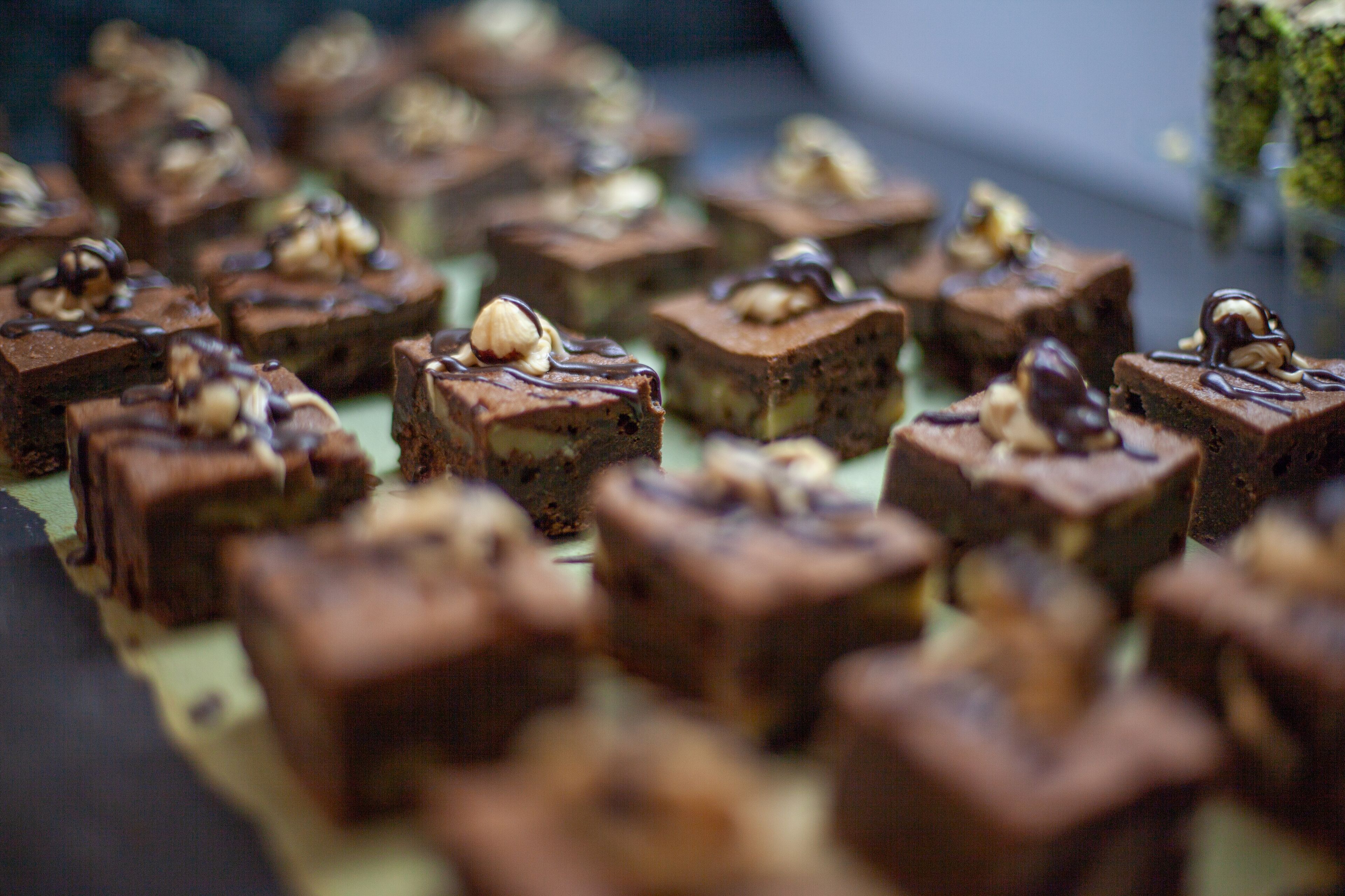 Una bandeja con varios brownies cuadrados cubiertos de nueces.