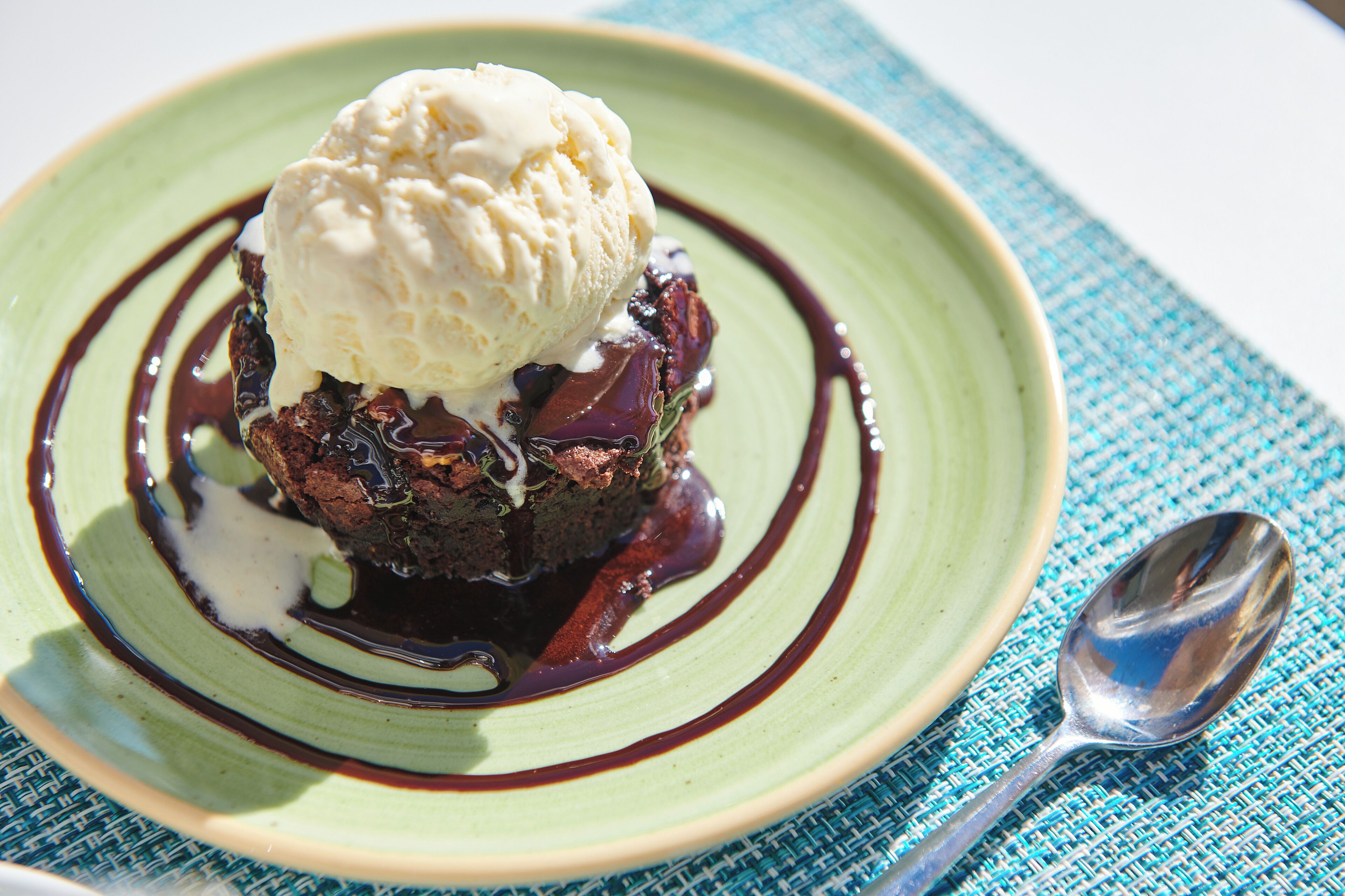 A dessert with ice cream on a plate with chocolate sauce.