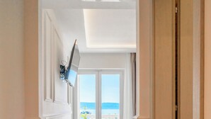 A hallway with a blue carpet leading to a balcony with a view of the sea. - Hotel Krilo (Dugi Rat)