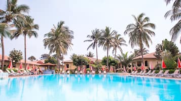 Una piscina al aire libre, sombrillas, sillones reclinables de piscina