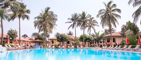 Una piscina al aire libre, sombrillas, tumbonas