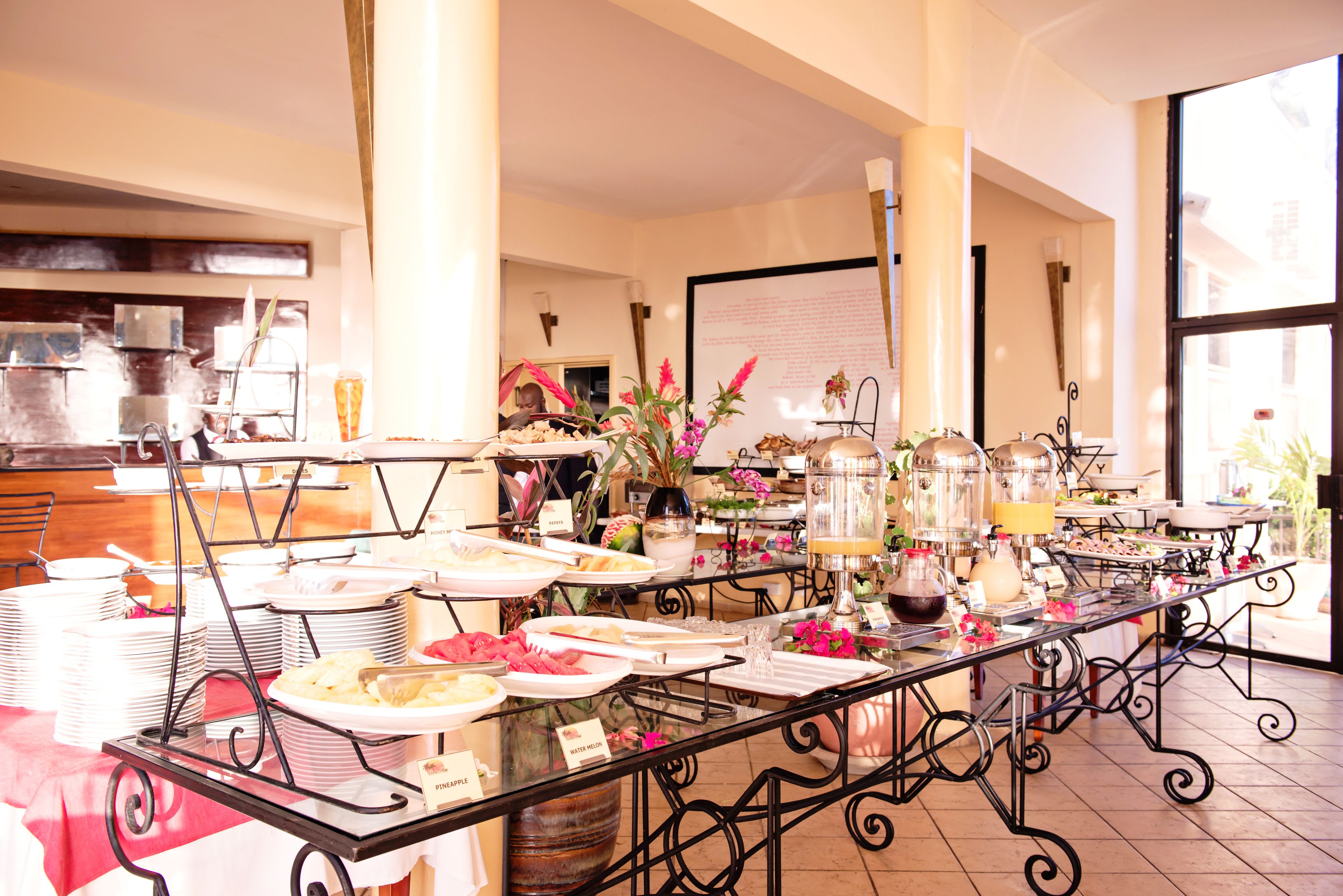 A buffet setup with various food items and beverages, arranged on tables with metal stands.