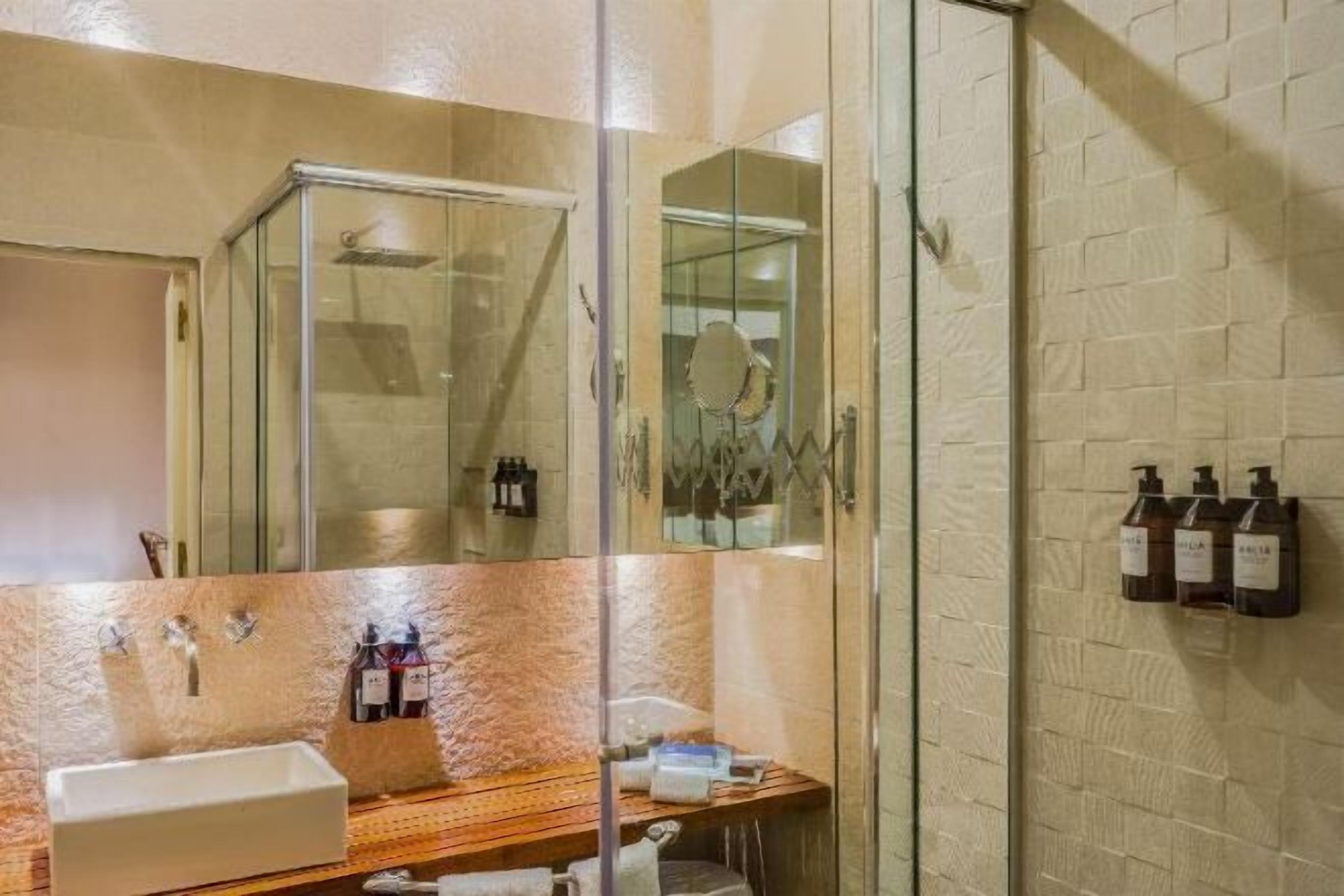 Badkamer | Een douche, designer toiletartikelen, een haardroger, badjassen