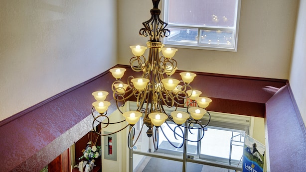 A chandelier with multiple light fixtures in a room with a window and a door.