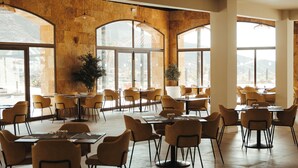 Un comedor amplio con techos altos, ventanas grandes y muebles modernos.